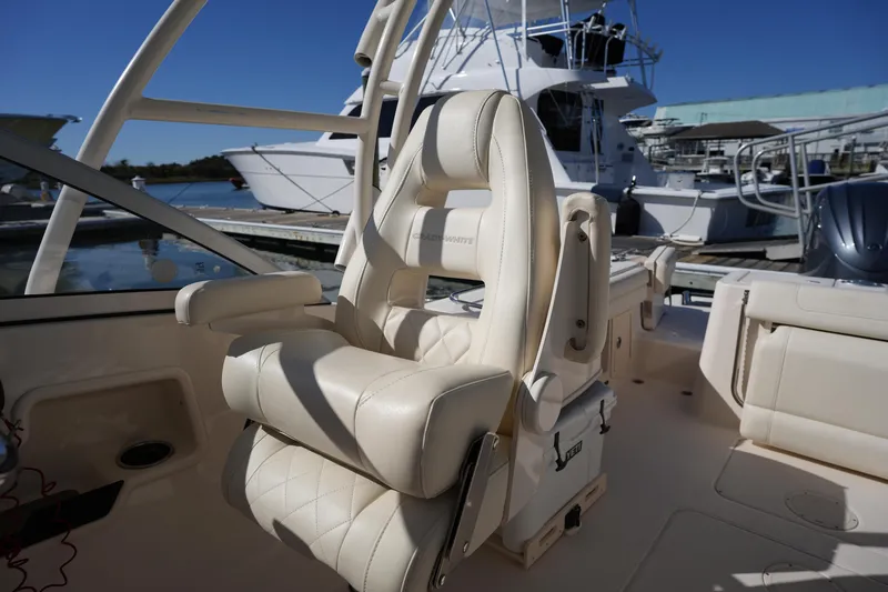 Slide: The Image of 2022 Grady-White Freedom 235 boat interior with luxurious seating at a marina. - 20
