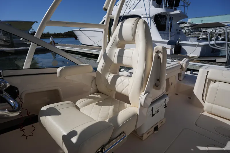 Slide: The Image of Luxury seating on 2022 Grady-White Freedom 235 boat, docked with other vessels. - 21