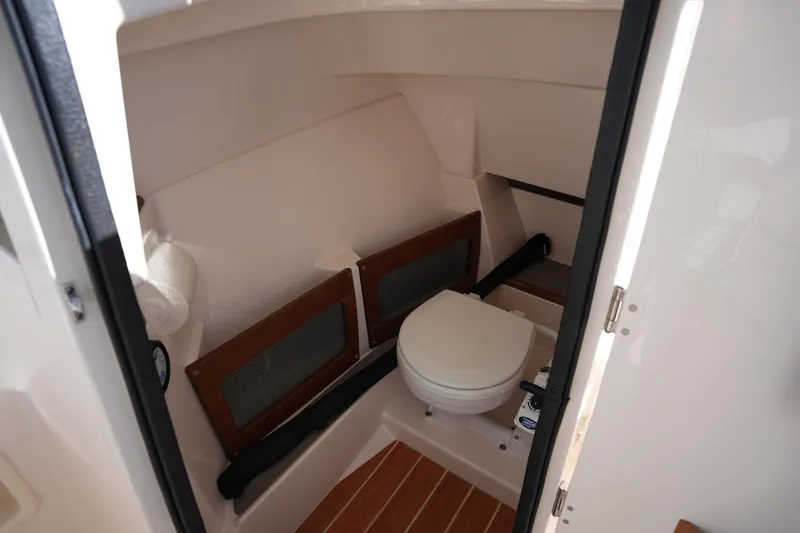 Slide: The Image of 2022 Grady-White Freedom 235 boat interior with compact marine toilet. - 26