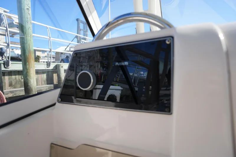 Slide: The Image of 2022 Grady-White Freedom 235 boat dashboard with steering wheel, docked at marina. - 27