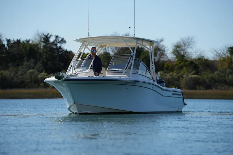 Slide: The Image of 2022 Grady-White Freedom 235 boat on calm water with trees in background. - 5