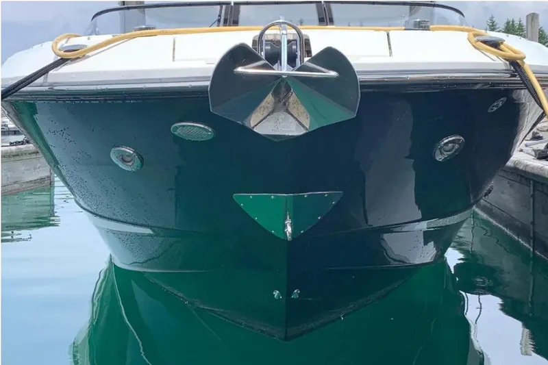 Slide: The Image of 2018 Sea Ray SLX 310 boat docked, front view with anchor and reflective water. - 2