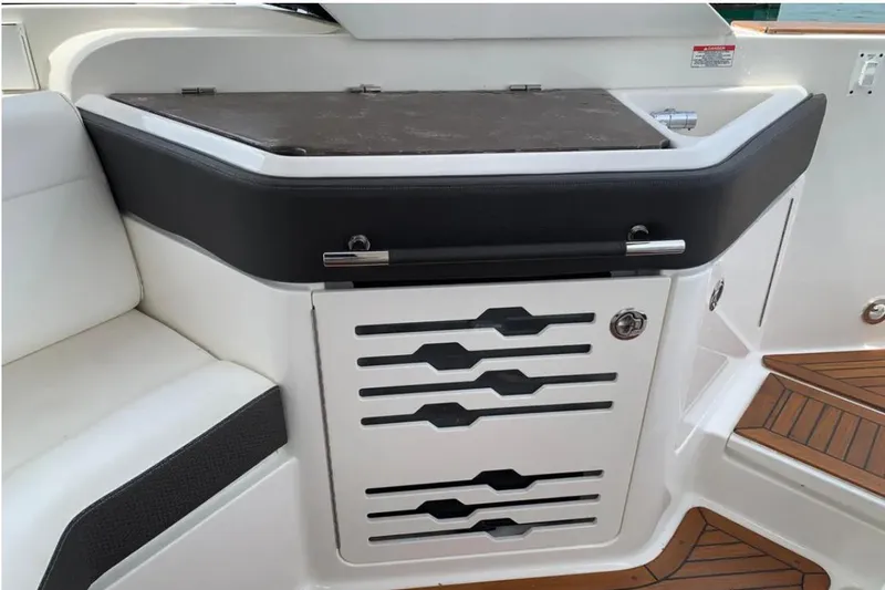 Slide: The Image of 2018 Sea Ray SLX 310 boat interior with sleek storage compartment and seating. - 21