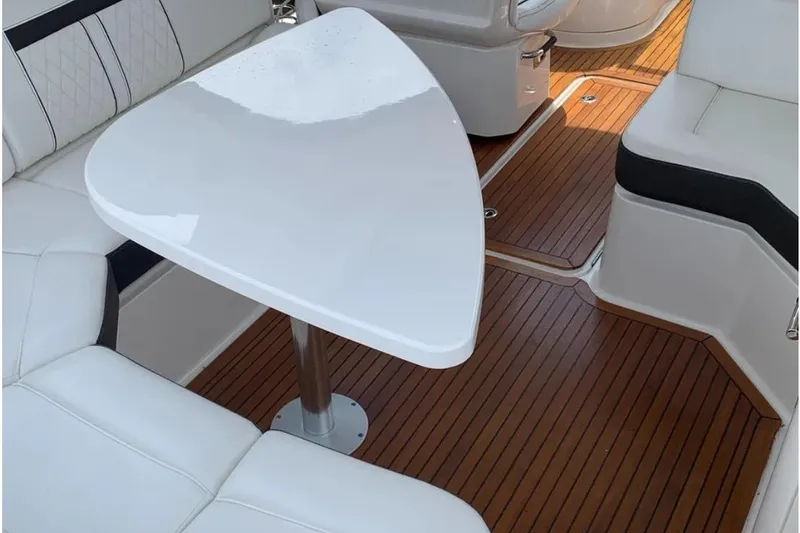 Slide: The Image of 2018 Sea Ray SLX 310 interior with white seating and wooden flooring. - 26