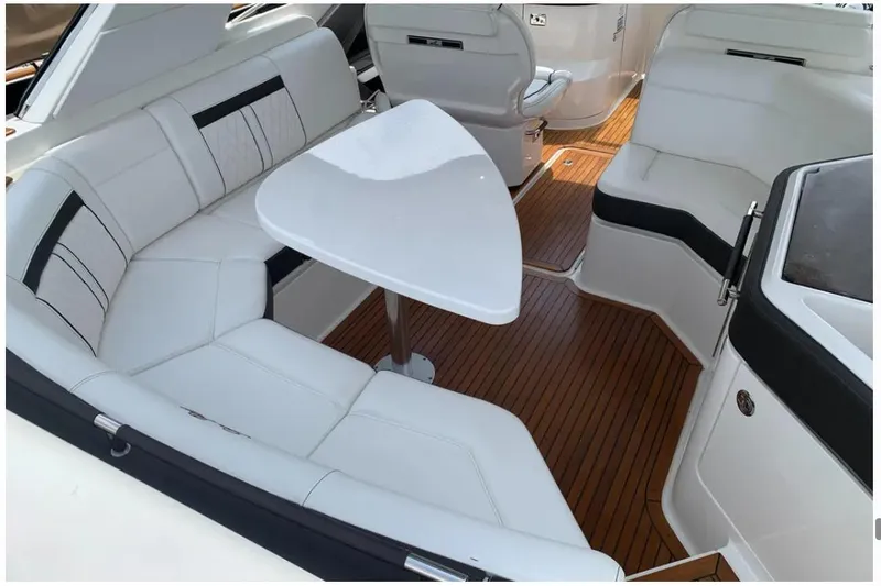 Slide: The Image of Luxurious 2018 Sea Ray SLX 310 boat interior with white seating and wooden flooring. - 27