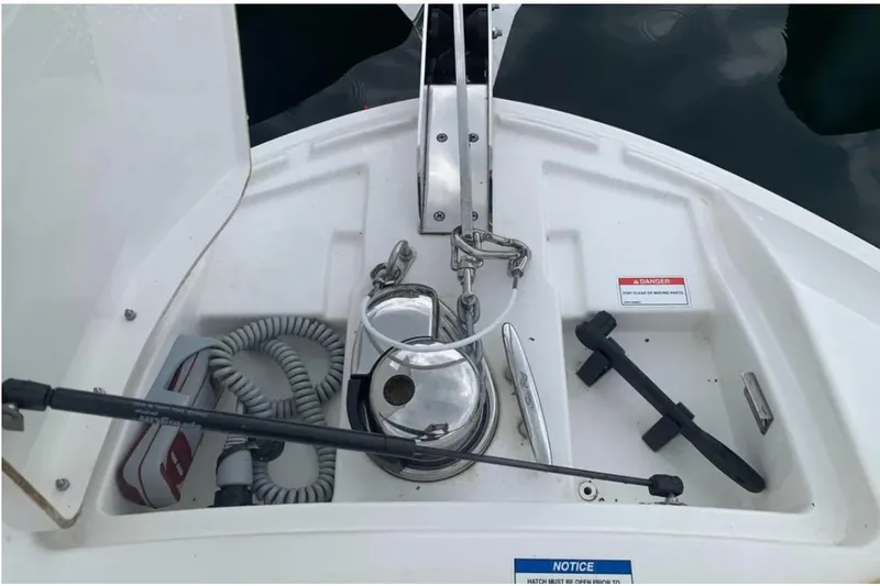 Slide: The Image of 2018 Sea Ray SLX 310 boat anchor compartment with winch and safety notices. - 3