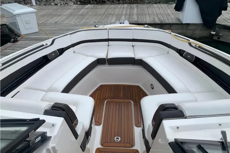 Slide: The Image of Luxurious 2018 Sea Ray SLX 310 boat interior with white seating and teak flooring. - 4