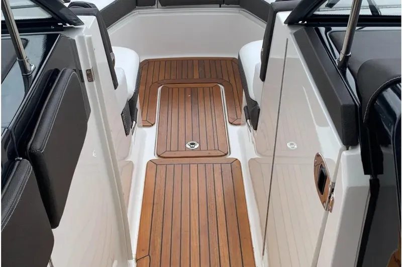 Slide: The Image of 2018 Sea Ray SLX 310 boat interior with teak flooring and black seating. - 7