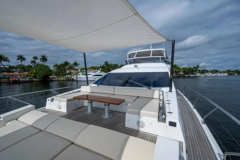 Slide: The Image of Luxurious 2017 Azimut 80 yacht deck with seating, table, and canopy on a scenic waterway. - 15