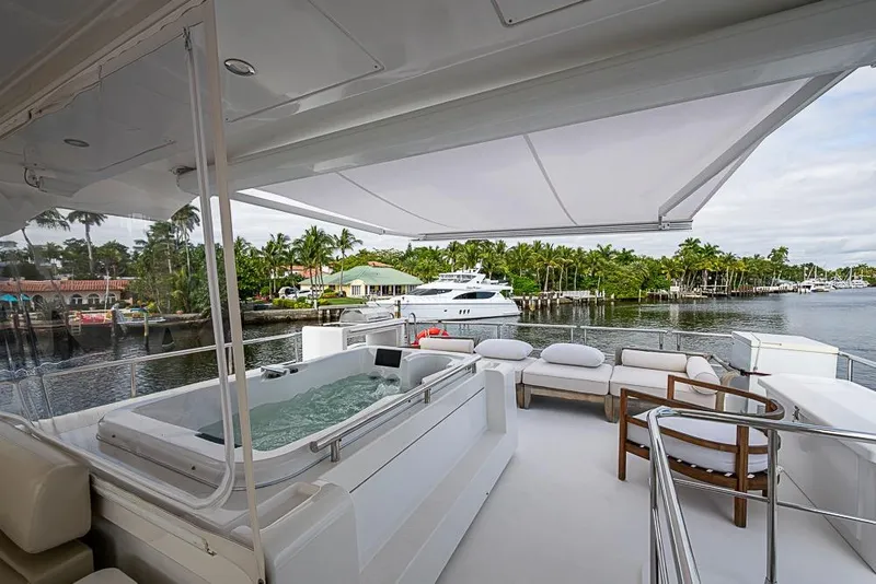 Slide: The Image of Luxurious 2017 Azimut 80 yacht deck with jacuzzi and seating area, overlooking serene waterfront. - 37