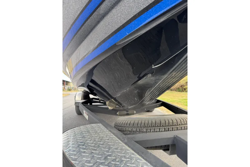 Slide: The Image of 2017 Triton 20 TrX Patriot boat on trailer, close-up view of hull and tire. - 11