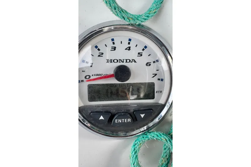 Slide: The Image of Honda tachometer on 2005 Glacier Bay 260 Canyon Runner boat, with green rope nearby. - 14