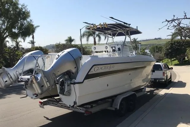 Slide: The Image of 2005 Glacier Bay 260 Canyon Runner boat on trailer, dual engines, parked outdoors. - 3