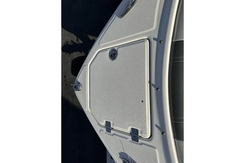 Slide: The Image of 2022 Chaparral 23 SSi OB boat deck with textured surface and metal hinges. - 13