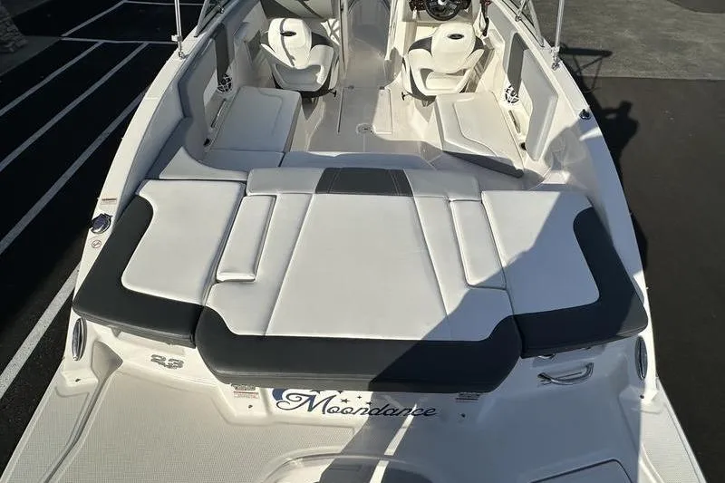 Slide: The Image of 2022 Chaparral 23 SSi OB boat interior with white seating and "Moondance" nameplate. - 17