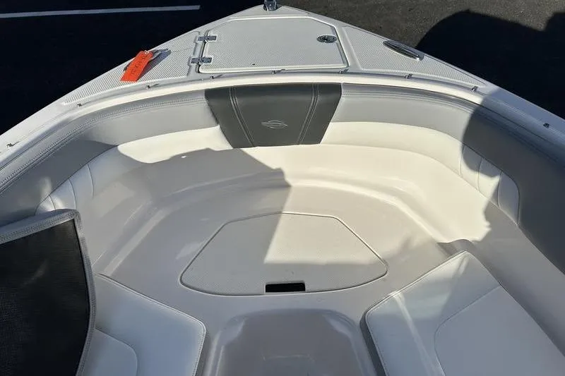Slide: The Image of 2022 Chaparral 23 SSi OB boat interior with cushioned seating and storage compartment. - 19