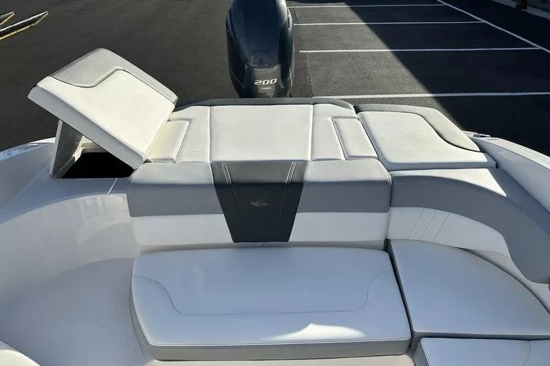 Slide: The Image of 2022 Chaparral 23 SSi OB boat with sleek white seating and powerful outboard motor. - 39