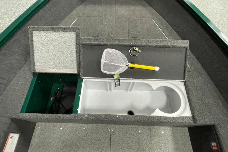 Slide: The Image of 2025 Lund 1650 Angler Tiller boat interior with storage compartments and fishing net. - 12