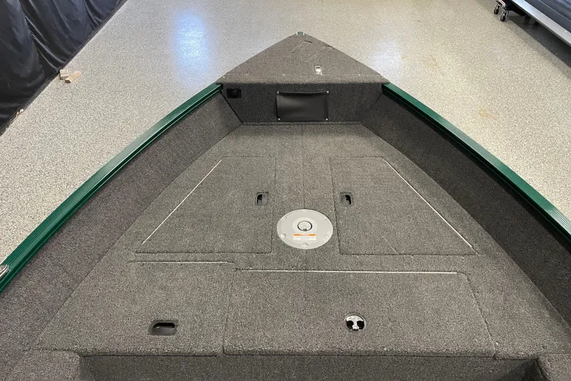 Slide: The Image of 2025 Lund 1650 Angler Tiller boat interior with gray carpeted deck. - 7