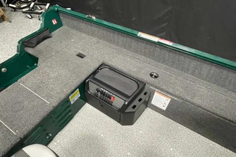 Slide: The Image of 2025 Lund 1650 Angler Tiller interior with gray carpet and control panel. - 9