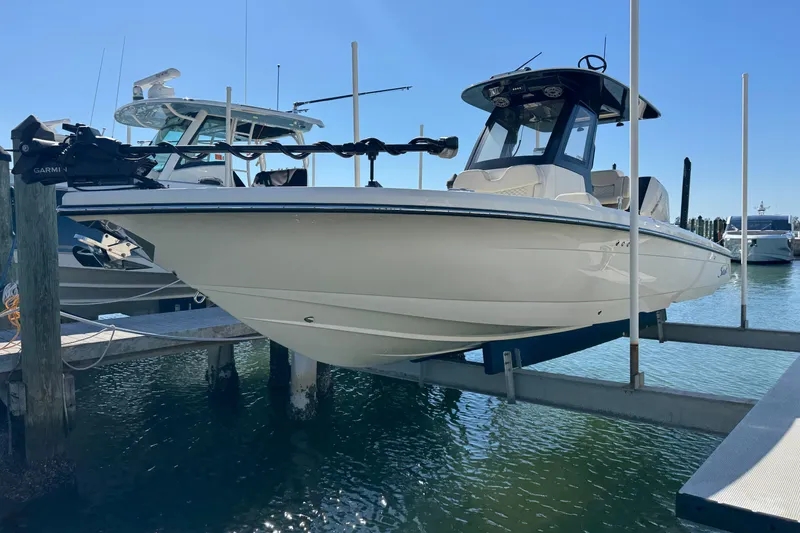 The Image of 2025 Scout 281 XSS boat docked on lift, sunny marina background. - 0