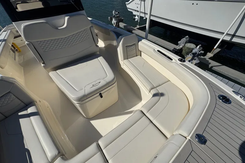 Slide: The Image of Luxurious seating area on 2025 Scout 281 XSS boat, docked by the water. - 10