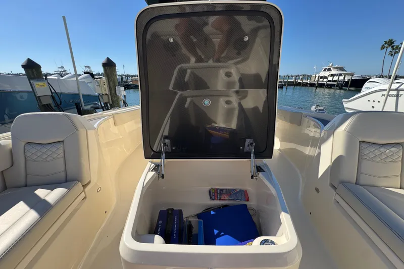 Slide: The Image of 2025 Scout 281 XSS boat storage compartment open at marina. - 12