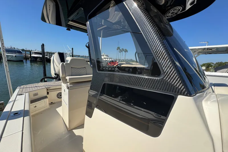 Slide: The Image of 2025 Scout 281 XSS boat with carbon fiber detailing docked at a marina. - 14