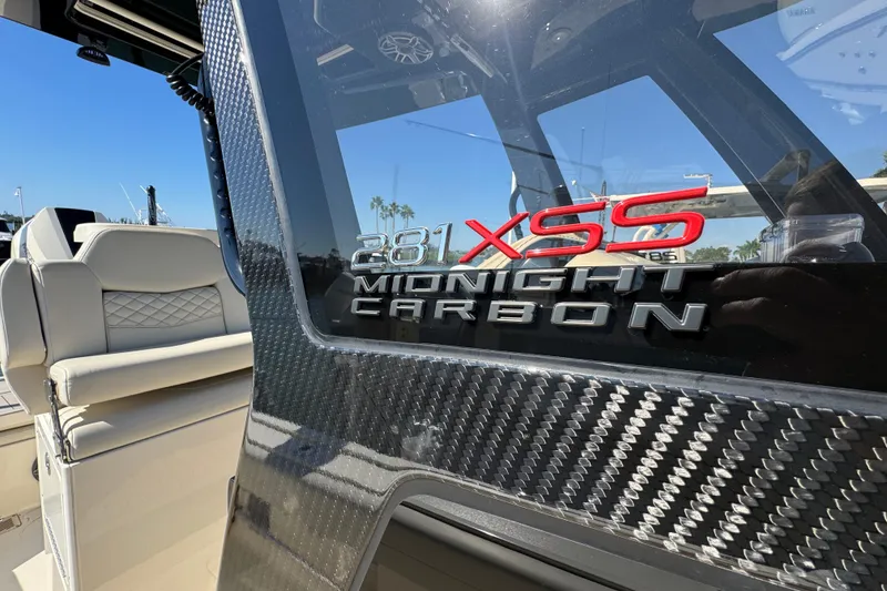 Slide: The Image of 2025 Scout 281 XSS Midnight Carbon boat interior with luxury seating and carbon fiber accents. - 15