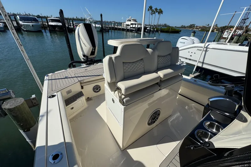 Slide: The Image of 2025 Scout 281 XSS boat interior with luxurious seating and modern design at a marina. - 16