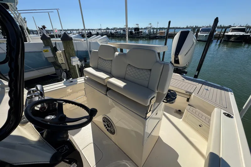 Slide: The Image of 2025 Scout 281 XSS boat interior with helm, seating, and water view. - 17