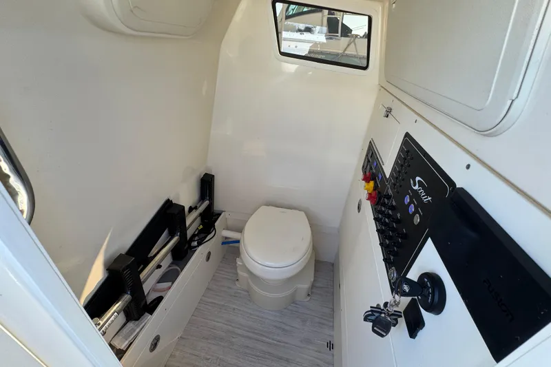 Slide: The Image of 2025 Scout 281 XSS boat interior with toilet and control panel. - 20