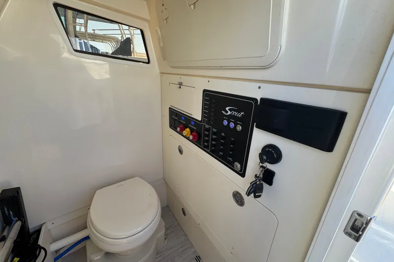 Slide: The Image of Interior of 2025 Scout 281 XSS boat featuring control panel and marine toilet. - 21