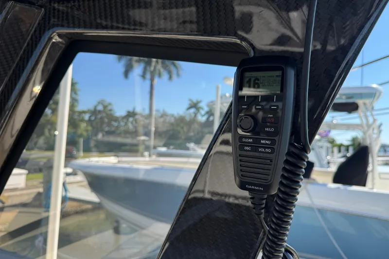 Slide: The Image of 2025 Scout 281 XSS boat interior with Garmin radio, docked near palm trees. - 24