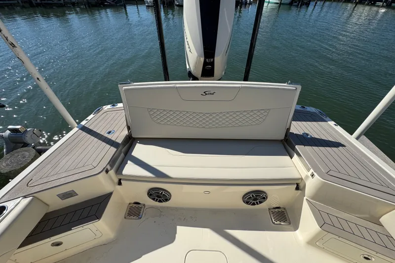 Slide: The Image of 2025 Scout 281 XSS boat interior with cushioned seating and water view. - 27