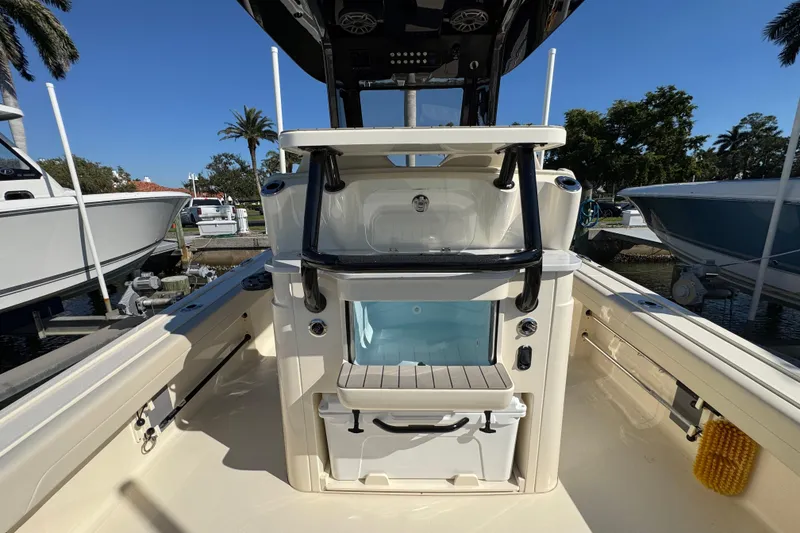 Slide: The Image of 2025 Scout 281 XSS boat interior with storage and seating, docked under clear blue sky. - 29