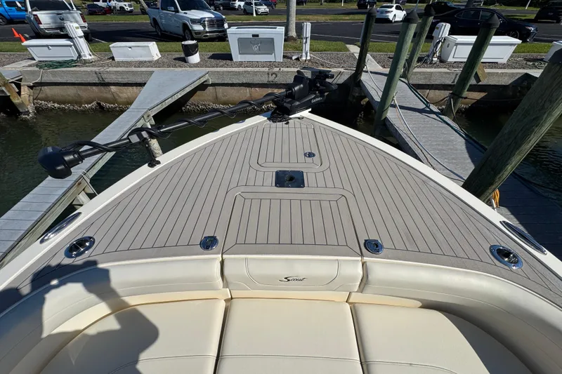 Slide: The Image of 2025 Scout 281 XSS boat bow with seating and deck at a marina dock. - 4