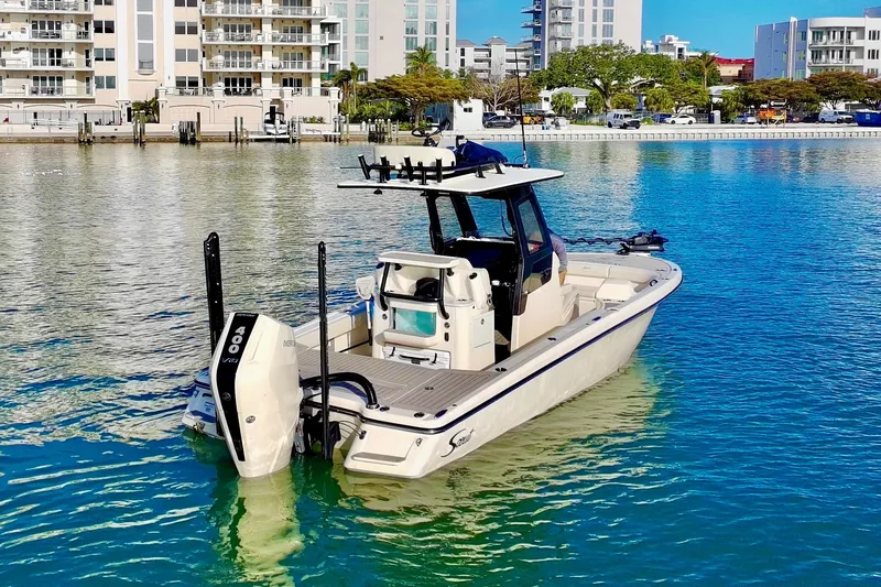 Slide: The Image of 2025 Scout 281 XSS boat docked in a marina with modern buildings in the background. - 41
