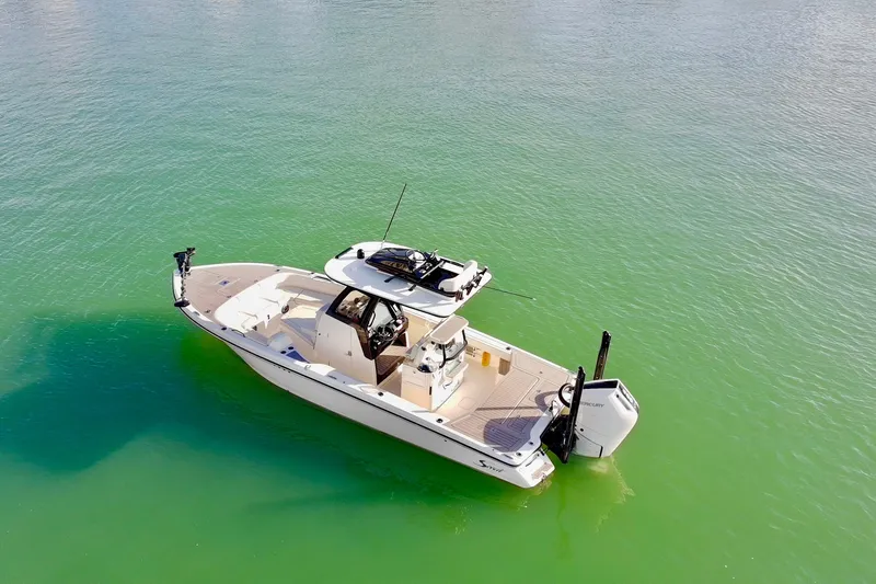 Slide: The Image of 2025 Scout 281 XSS boat on calm green water, aerial view. - 44