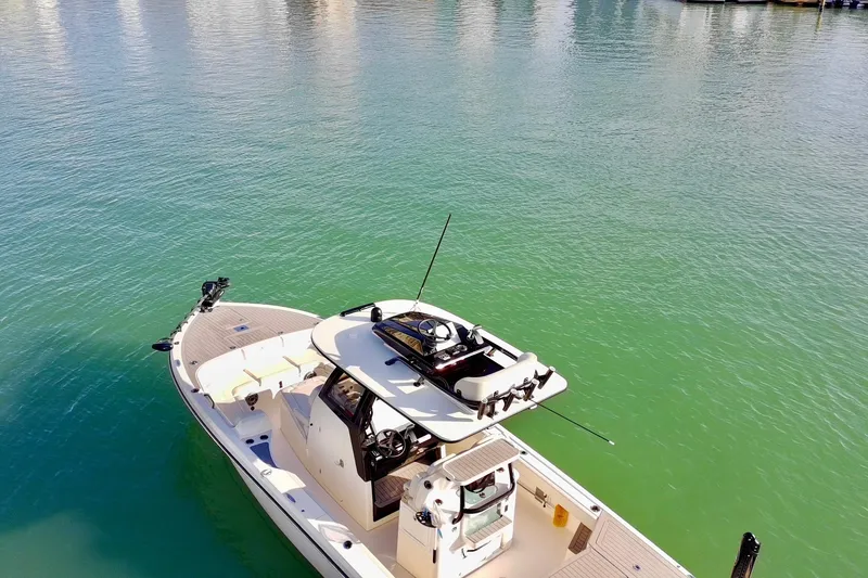 Slide: The Image of 2025 Scout 281 XSS boat on calm green water, aerial view. - 45