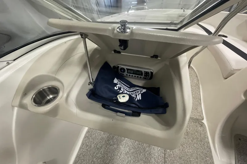 Slide: The Image of 2010 Glastron GT 185 boat storage compartment with carpeted interior and organized shelving. - 14