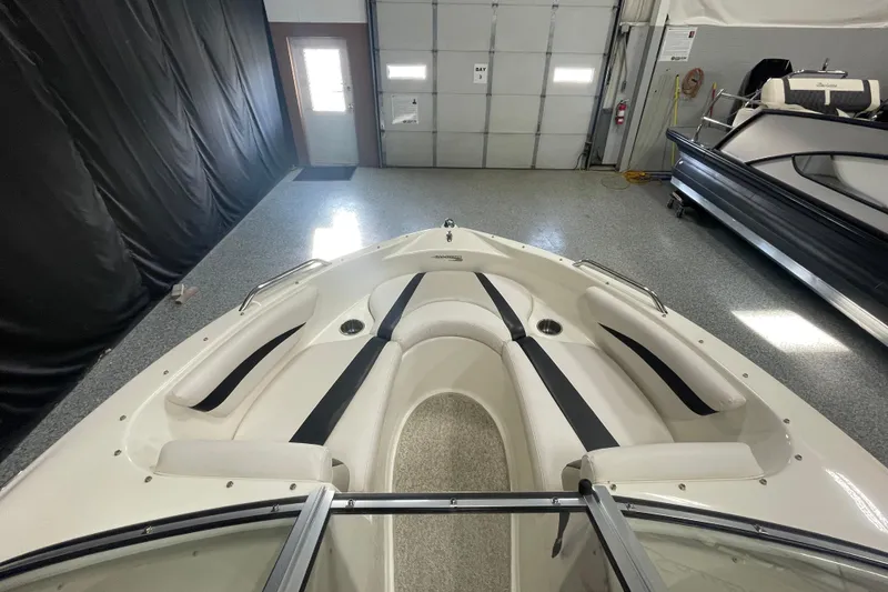 Slide: The Image of 2010 Glastron GT 185 boat interior with seating and steering wheel in showroom. - 7