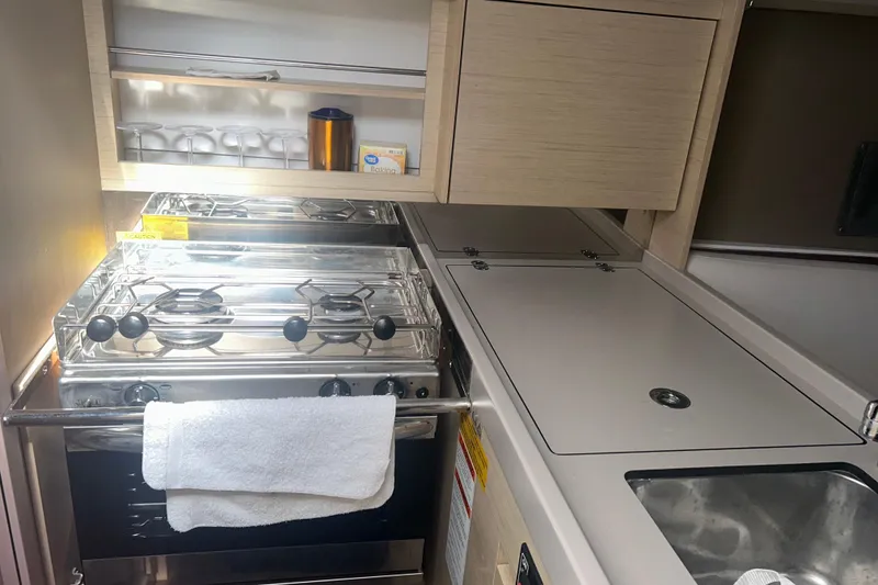 Slide: The Image of Compact kitchen in a 2020 Beneteau Oceanis 30.1 yacht with stove and sink. - 7