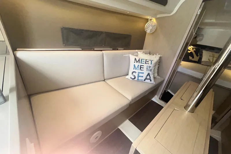 Slide: The Image of Interior of 2020 Beneteau Oceanis 30.1 yacht with cozy seating and nautical decor. - 9