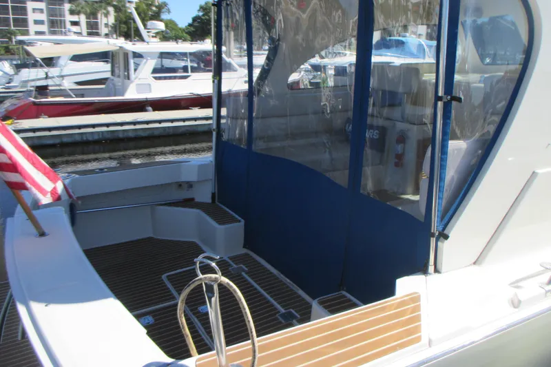 Slide: The Image of 2005 Mainship Pilot 34 Sedan boat with American flag, docked at marina. - 10
