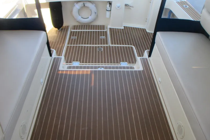 Slide: The Image of 2005 Mainship Pilot 34 Sedan interior with teak flooring and cushioned seating. - 14