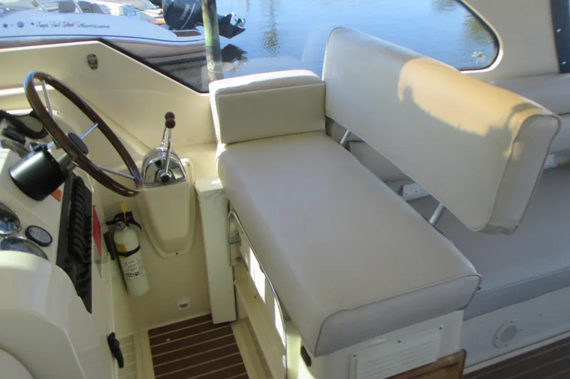 Slide: The Image of 2005 Mainship Pilot 34 Sedan interior with steering wheel and cushioned seating. - 20