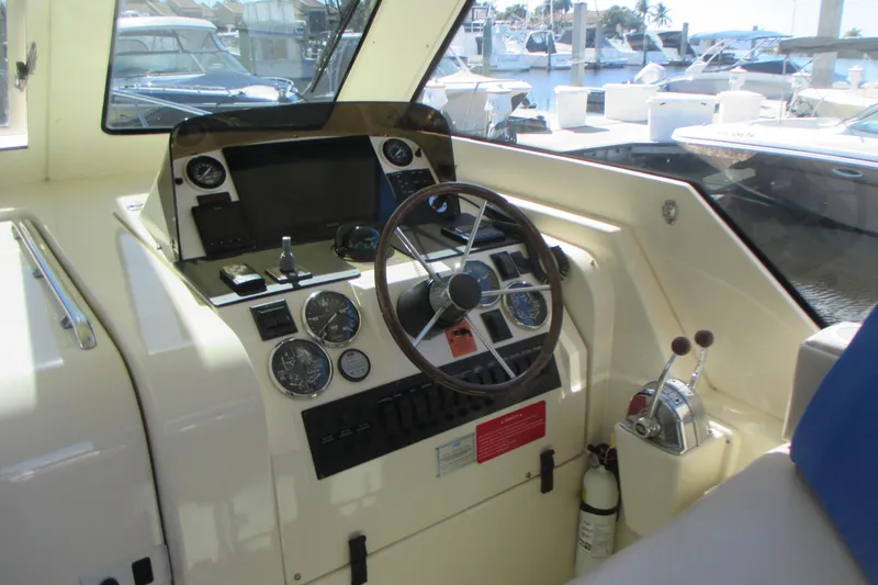 Slide: The Image of 2005 Mainship Pilot 34 Sedan helm with steering wheel and control panel. - 21