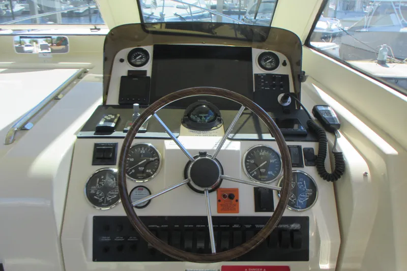 Slide: The Image of 2005 Mainship Pilot 34 Sedan helm with gauges, steering wheel, and communication equipment. - 22
