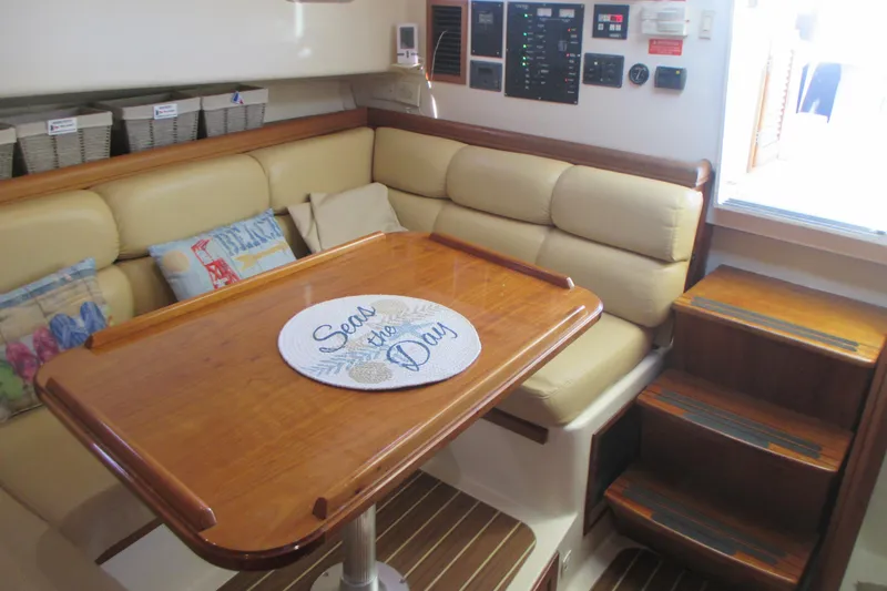 Slide: The Image of 2005 Mainship Pilot 34 Sedan interior with cozy seating and wooden table. - 24